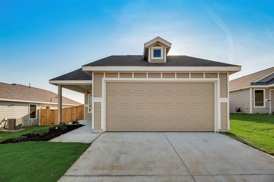 View of front facade featuring a garage, central air condition unit, and a front lawn