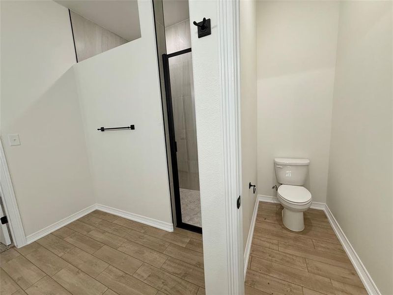 Bathroom with wood finished floors and a shower stall
