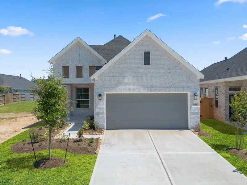 Front exterior of a new home in Emory Glen, Magnolia, TX, highlighting curb appeal (Image 1).