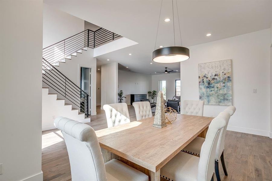 Dining room with light wood finished floors, recessed lighting, and stairway Dining room with light wood finished floors, recessed lighting, and stairway