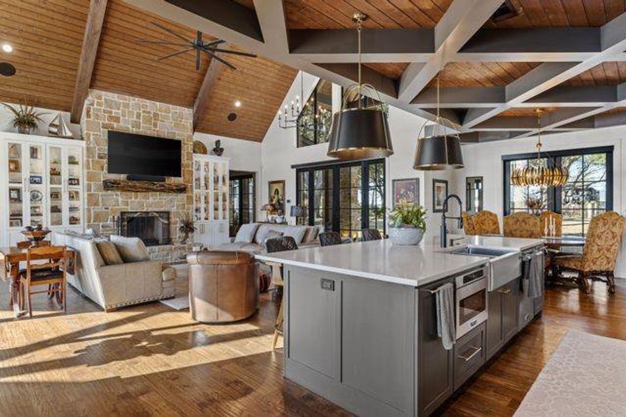 Kitchen featuring dark wood-style flooring, a wooden ceiling with exposed beams, a chandelier, a fireplace, and hanging light fixtures