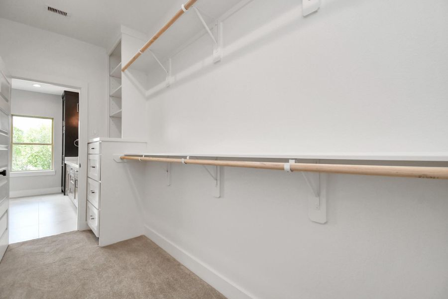 Adjacent to the primary ensuite bathroom, we see the expansive walk-in closet with built-in cabinetry and shelving! Adjacent to the primary ensuite bathroom, we see the expansive walk-in closet with built-in cabinetry and shelving!