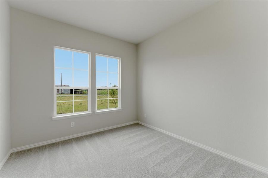 Unfurnished room featuring light carpet and baseboards