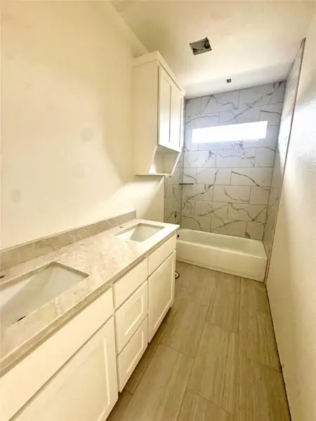 Double vanities and an elegantly tiled shower-tub combination define this well-appointed bathroom.