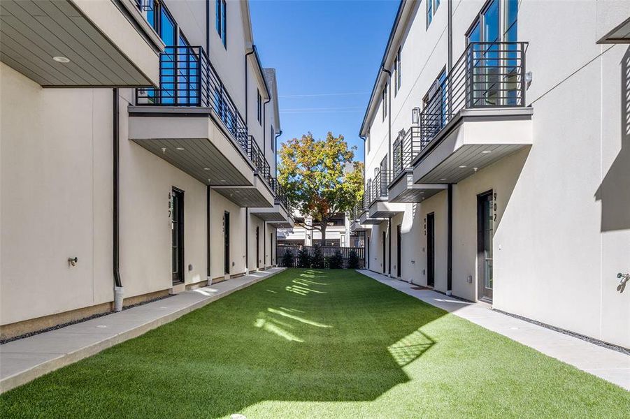 View of community featuring a yard and a balcony View of community featuring a yard and a balcony