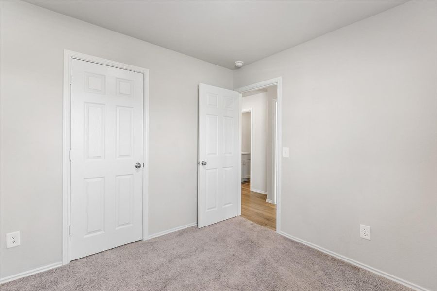 Secondary bedroom with closet and carpet. Secondary bedroom with closet and carpet.