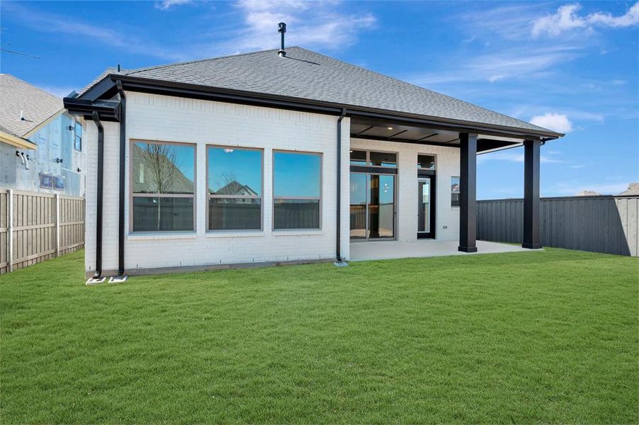Rear view of property with brick siding, a fenced backyard, roof with shingles, and a patio area Rear view of property with brick siding, a fenced backyard, roof with shingles, and a patio area