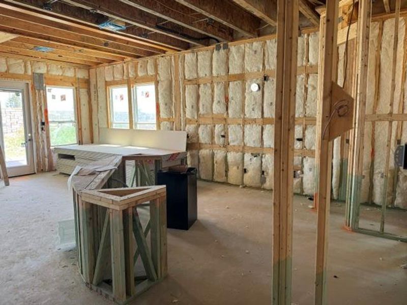 Framed walls and exposed insulation hint at the exciting potential within this new construction.