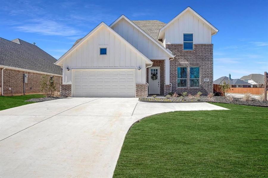 View of front of home with a garage and a front yard