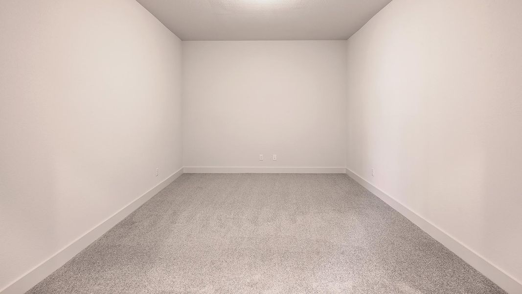 Empty room featuring light colored carpet and baseboards