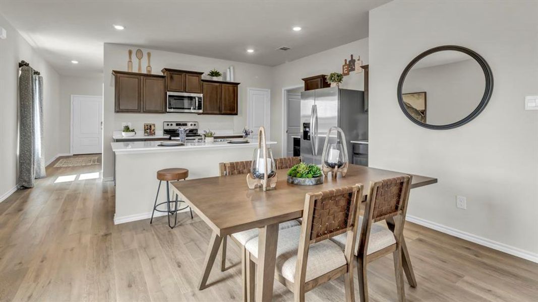 Open-concept living space with wood-finish flooring Open-concept living space with wood-finish flooring