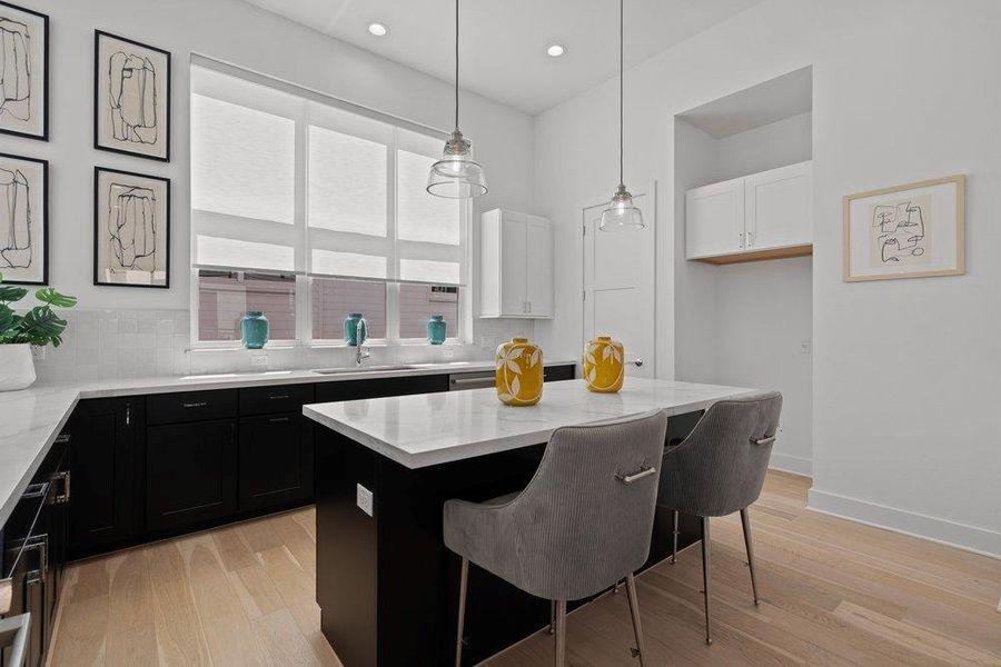 Culinary delights await in this modern kitchen, featuring a spacious island with seating and ample cabinetry. Culinary delights await in this modern kitchen, featuring a spacious island with seating and ample cabinetry.
