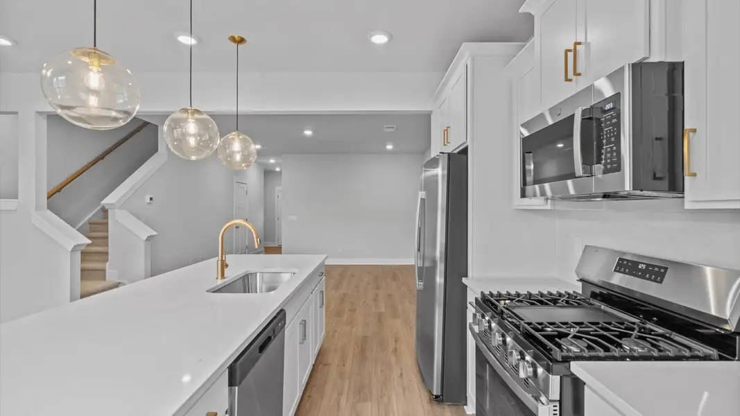 Tasteful design meets functional luxury in this kitchen with a 9-foot island and modern pendant lighting Tasteful design meets functional luxury in this kitchen with a 9-foot island and modern pendant lighting