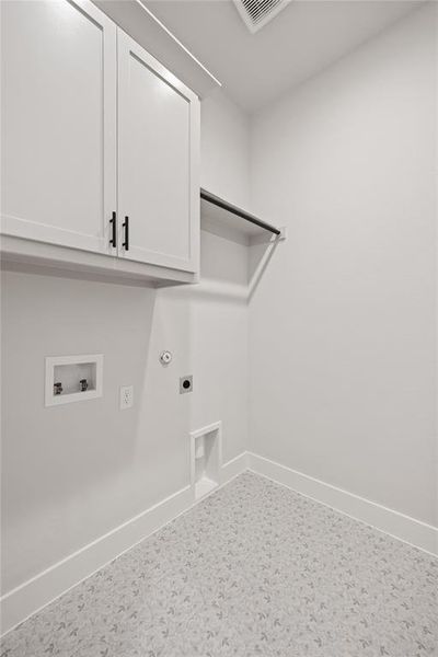 Dedicated laundry area featuring white shaker-style cabinetry with matte black hardware