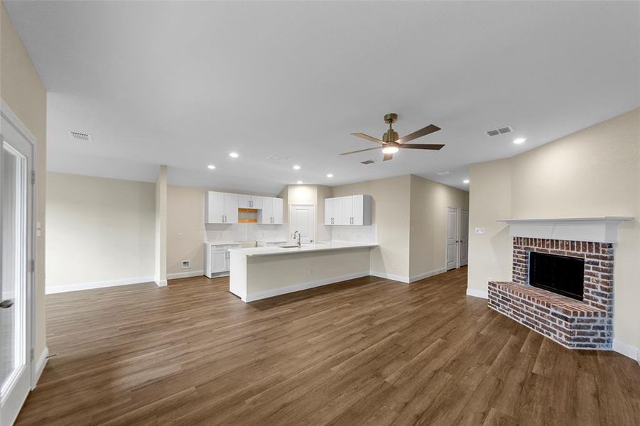 Open-concept living space featuring wood-finish flooring, recessed lighting, and a ceiling fan