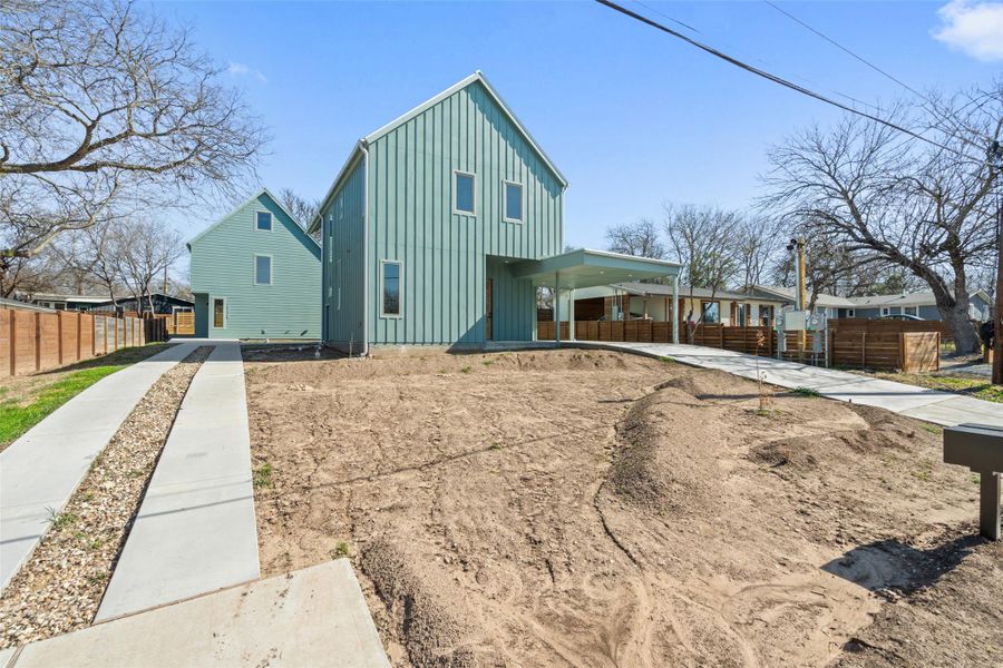 View of front of home featuring board and batten siding, covered porch, and fence