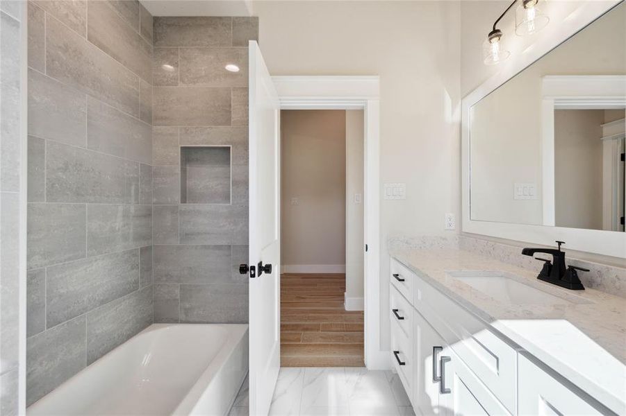 Bathroom featuring vanity, wood-type flooring, and tiled shower / bath combo