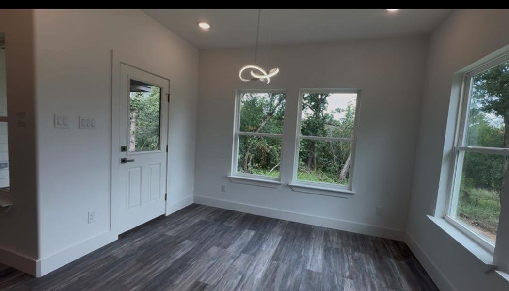 Interior space with wood-finish flooring, recessed lighting, and a modern ceiling fixture
