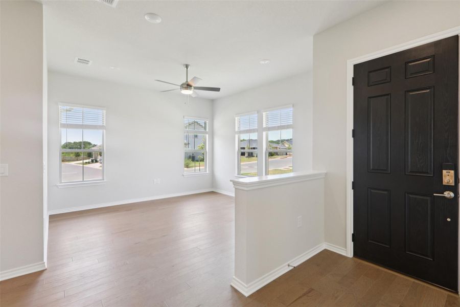 Entrance foyer featuring plenty of natural light, dark wood-style floors, and a ceiling fan Entrance foyer featuring plenty of natural light, dark wood-style floors, and a ceiling fan