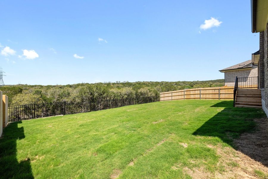 View of yard featuring a fenced backyard and a forest view View of yard featuring a fenced backyard and a forest view
