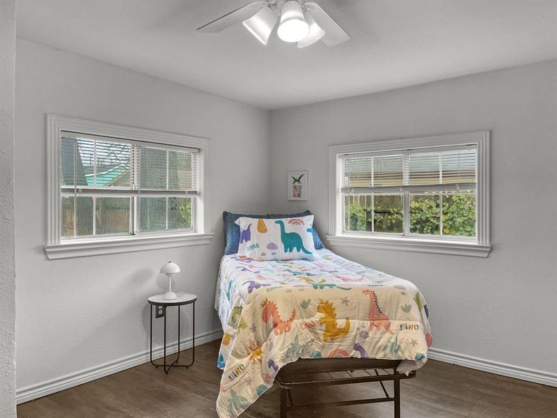 Bedroom #2 with multiple windows, ceiling fan, and dark wood-type flooring