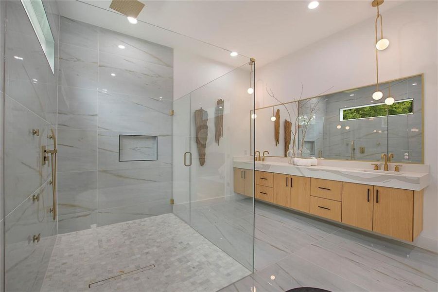 Full bathroom with a marble finish shower, double vanity, and marble look tiles Full bathroom with a marble finish shower, double vanity, and marble look tiles