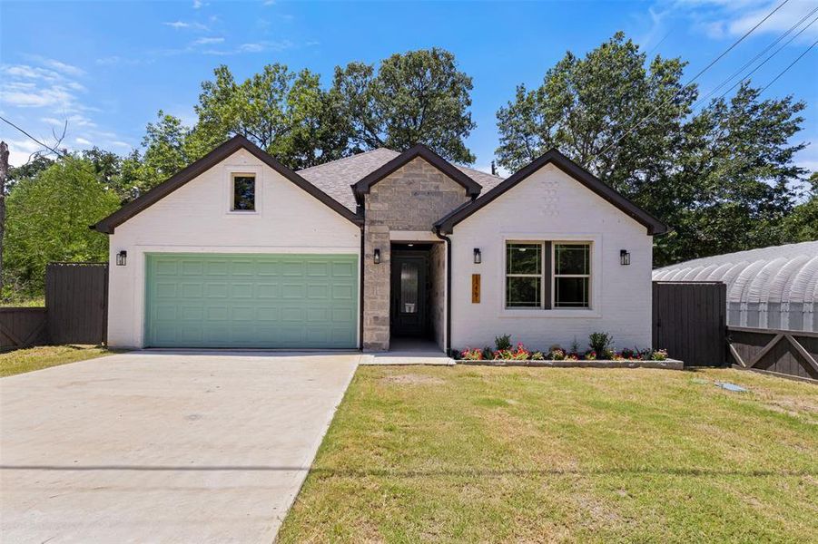 View of front of home with a garage, concrete driveway, brick siding, and stone siding View of front of home with a garage, concrete driveway, brick siding, and stone siding