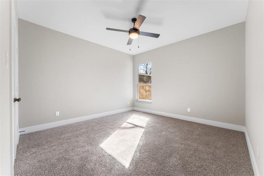 Spare room with ceiling fan and carpet floors