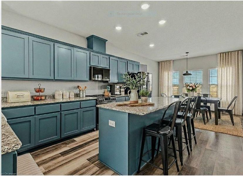 STAGED PHOTO of kitchen looking towards dining area