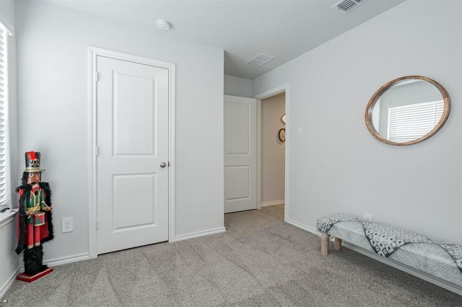 Carpeted bedroom with visible vents and baseboards