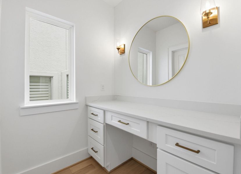 Dedicated vanity area with custombuilt-ins, generous storage, andbeautiful natural light. (Photo of a previous build, similar finishes.)
