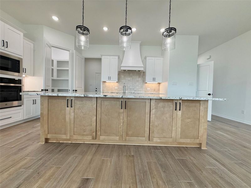 Kitchen island featuring wood-finish cabinetry and a light-toned countertop