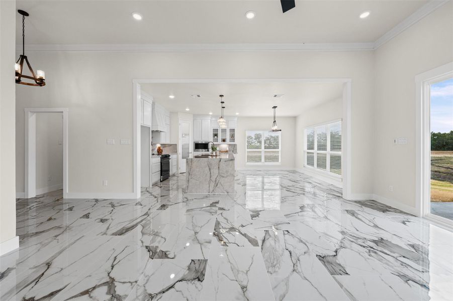 Polished stone floors and large windows define this airy open-concept living space.