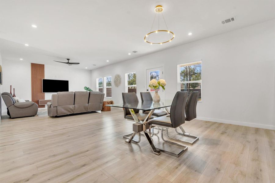 Dining room with light wood-style flooring, ceiling fan, and recessed lighting