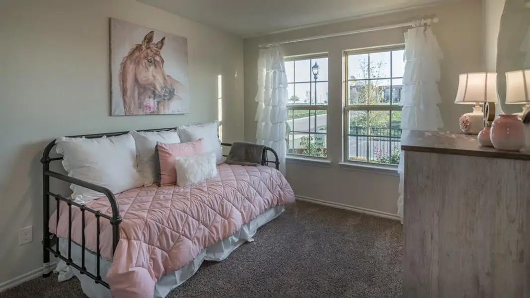 Room featuring two windows with white trim, a textured wall finish, and neutral-toned carpeting