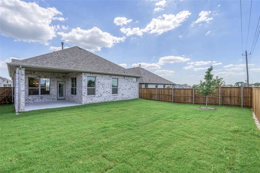 Rear view of property featuring a fenced backyard, roof with shingles, brick siding, and a patio area Rear view of property featuring a fenced backyard, roof with shingles, brick siding, and a patio area