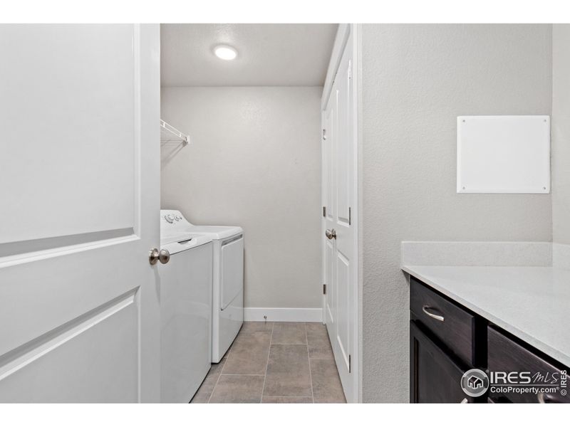 Full laundry room w/ built in cabinets & quartz countertops