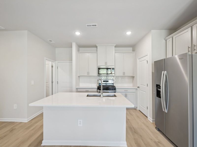 The spacious kitchen island is at the heart of the open-concept first floor.