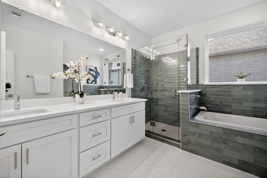 Full bathroom featuring a garden tub, light tile patterned floors, double vanity, and a stall shower Full bathroom featuring a garden tub, light tile patterned floors, double vanity, and a stall shower