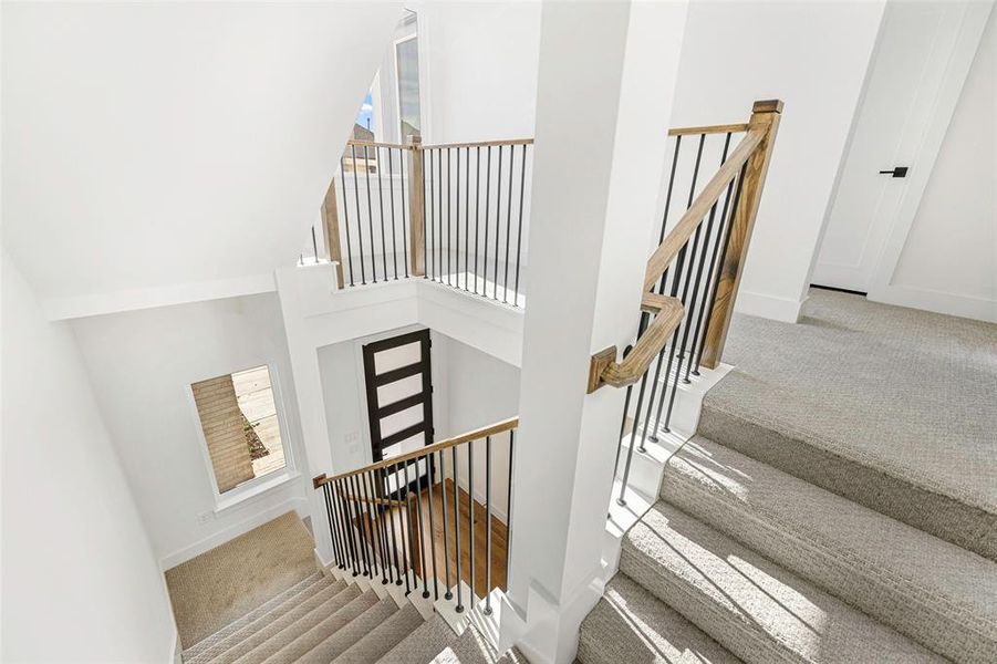 Stairs featuring carpet flooring, a towering ceiling, and baseboards