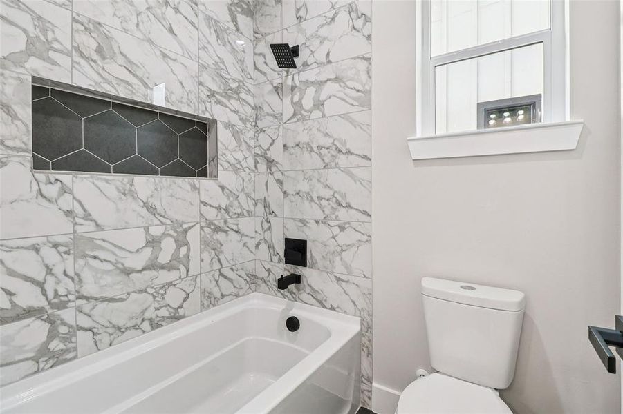 Bathroom featuring shower / washtub combination and a fireplace