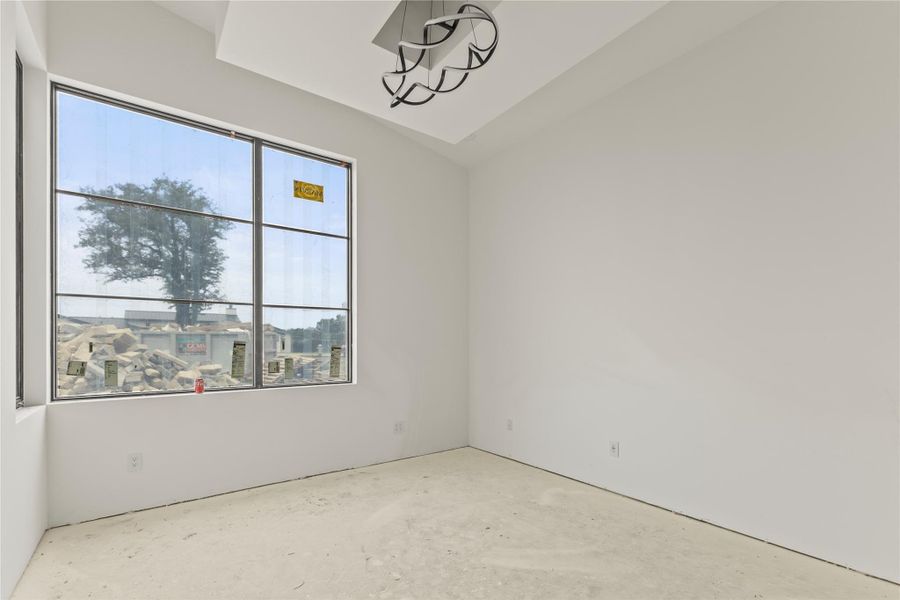 Room featuring a large grid-pattern window, white walls, and a contemporary ceiling light fixture
