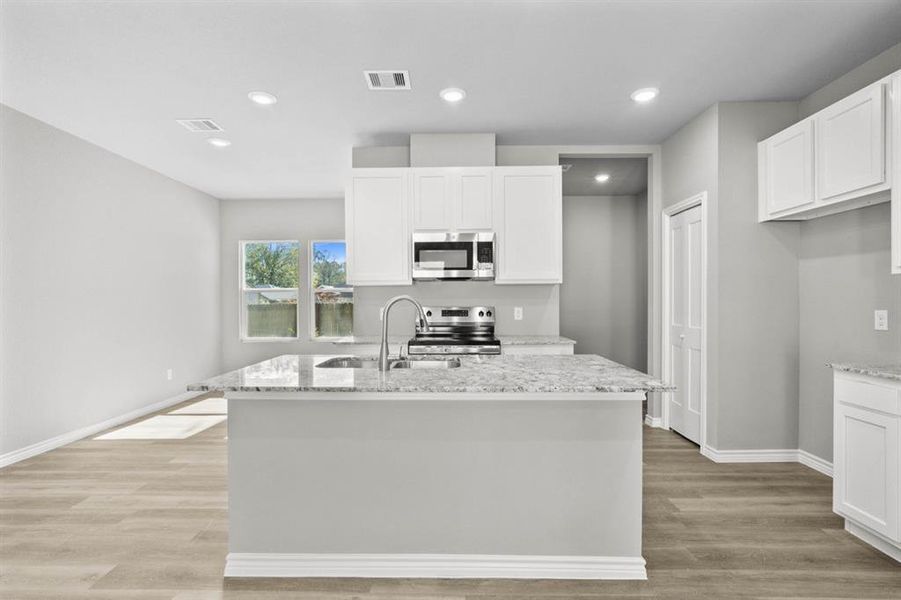 Light and bright kitchen offering ample room for cooking, storage and entertaining.  Dining room to the left, utility, mud room and entry to the garage is to the right.