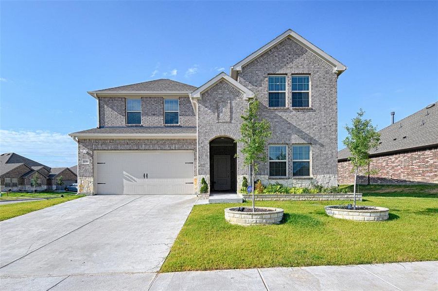 View of front of home featuring a garage and a front yard