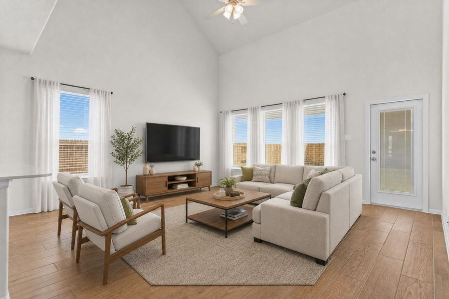 Spacious family room filled with natural light and soaring ceilings that create an open and inviting atmosphere. Large windows overlook the backyard while the beautiful wood looking tile flooring continues throughout the main living areas, making this the perfect place for relaxing or entertaining. *Photo is Virtually Staged*