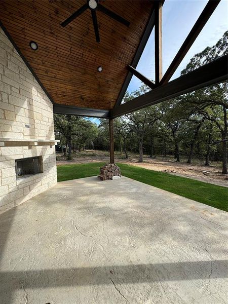 View of patio featuring a ceiling fan and an outdoor stone fireplace View of patio featuring a ceiling fan and an outdoor stone fireplace