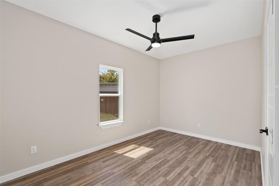 Unfurnished room with wood finished floors and a ceiling fan