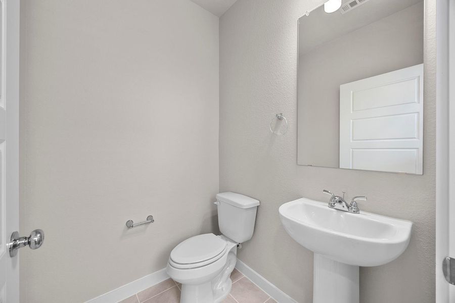 A pristine powder room featuring a modern pedestal sink and essential fixtures, ideal for guests. A pristine powder room featuring a modern pedestal sink and essential fixtures, ideal for guests.