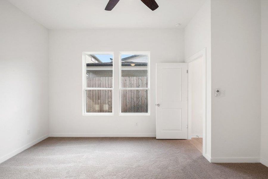 Unfurnished room with carpet and a ceiling fan