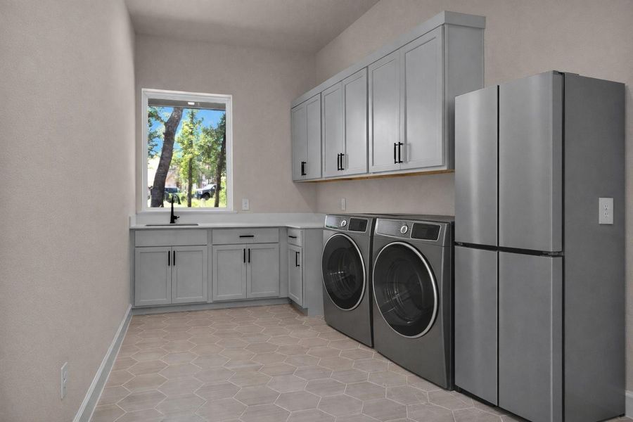 (Virtually staged) This wellequipped utility room featureshexagon tile flooring, upper andlower cabinetry, a built-in sinkand is prepped with plumbingand electrical for a full-sizerefrigerator.